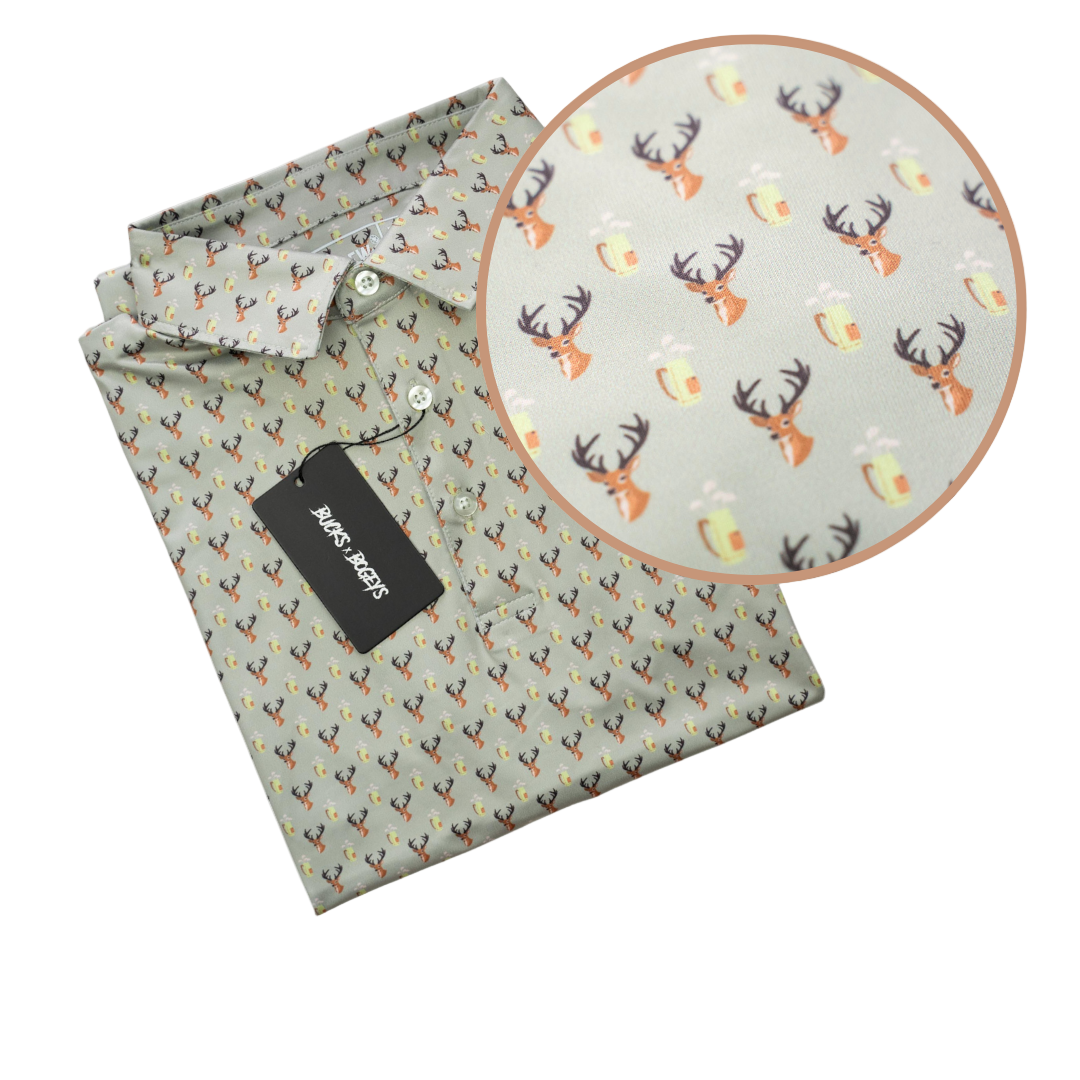 Folded shirt with a pattern of deer heads and antlers on a light green background, with a close-up inset showing the pattern.