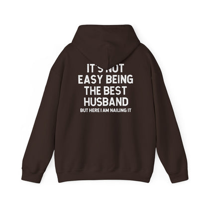 Best Husband Hoodie featuring white text on black fabric, stating "It's Not Easy Being THE BEST HUSBAND But Here I Am Nailing It".