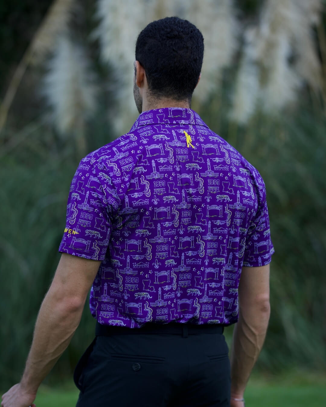 Man wearing Baton Rouge football polo shirt by Haven Golf with purple Play Neck design.