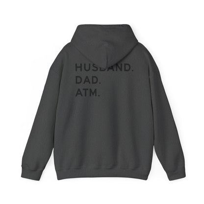 Husband Dad ATM Hoodie featuring bold black lettering on the back saying "HUSBAND. DAD. ATM." in a stylish design.