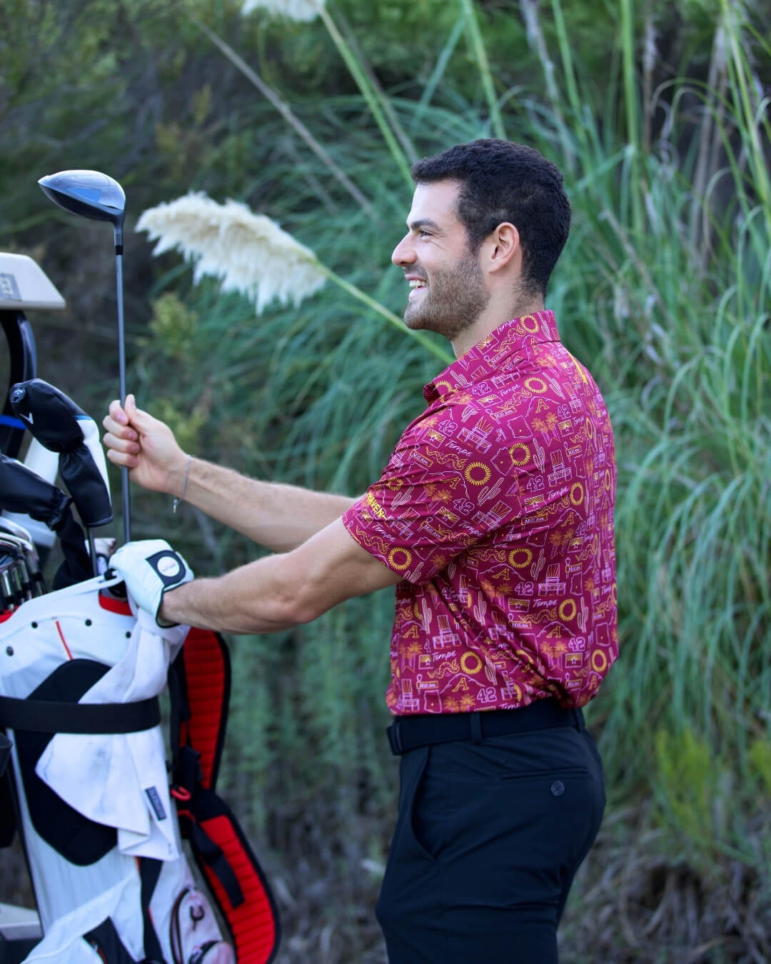 Man wearing Tempe football polo shirt "The Inferno" with golf gear outdoors