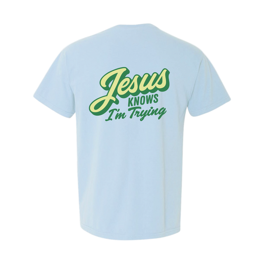 Light blue t-shirt with 'Jesus Knows I'm Trying' text in green on a white background