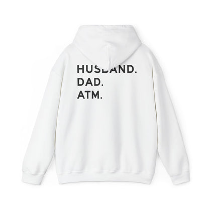 Husband Dad ATM Hoodie featuring bold black lettering "HUSBAND. DAD. ATM." on the back in a classic white design.