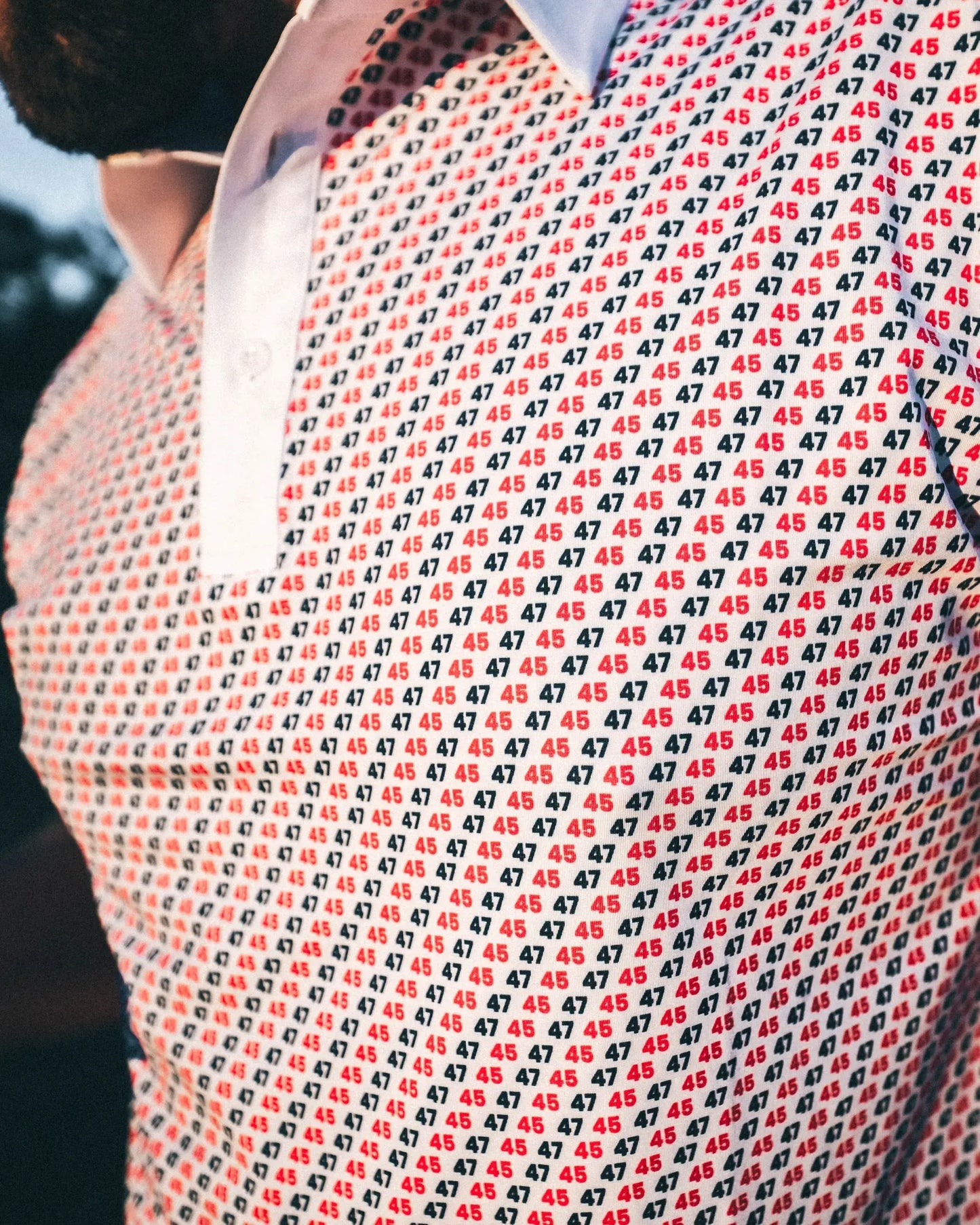 Close-up of a 45 47 polo shirt featuring a red and navy repeating pattern, showcasing the Commander in Chief style.