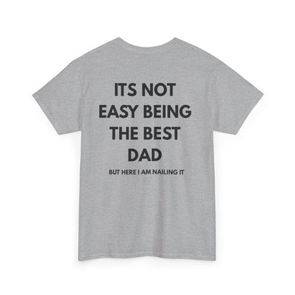 Not Easy Being The Best Dad But Here I Am Nailing It Shirt displayed on a gray t-shirt.