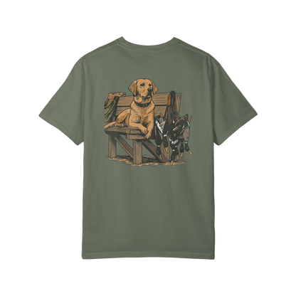 Green t-shirt with a graphic of a dog and hunting equipment on the back, on a white background.