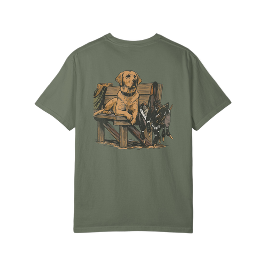 Green t-shirt with a graphic of a dog and hunting equipment on the back, on a white background.