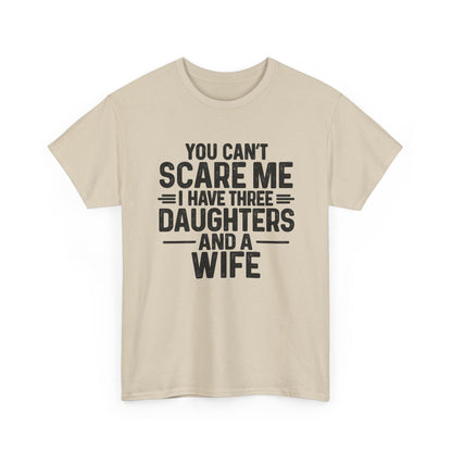 You Can't Scare Me I Have Three Daughters And A Wife Shirt displayed on a beige t-shirt with bold text design.