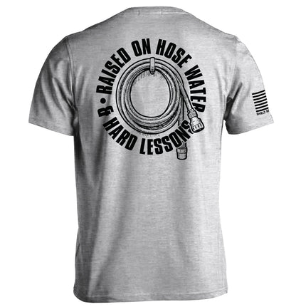 Back view of Raised On Hose Water & Hard Lessons Shirt with hose design, symbolizing blue collar nostalgia.