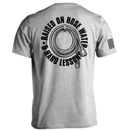 Back view of Raised On Hose Water & Hard Lessons Shirt featuring hose and flag design.