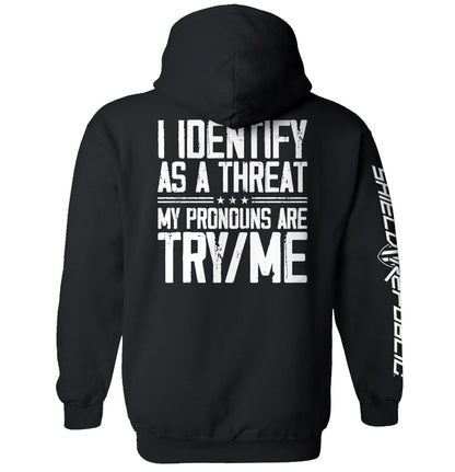 Black hoodie with 'I Identify As A Threat' bold white text, rugged military-style typography, expresses strength and independence.