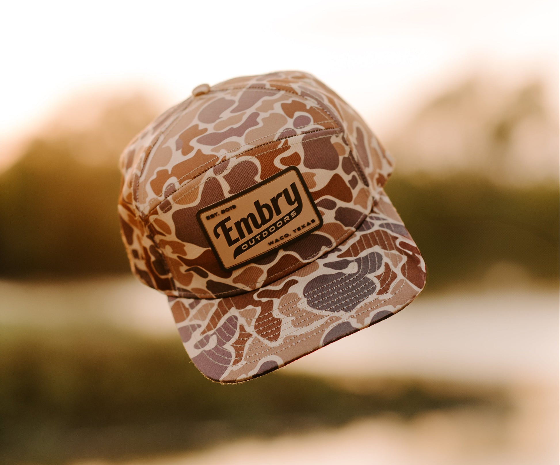 Duck Camo 6 Panel "Retro" Trucker hat with Embry Outdoors logo in outdoors setting