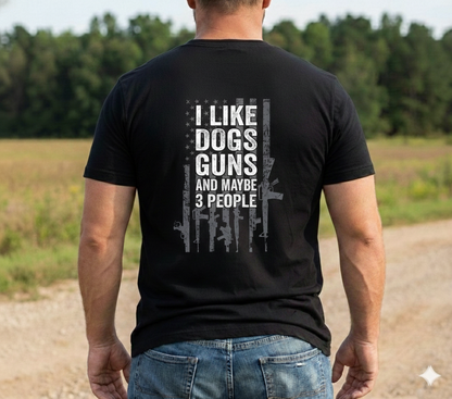 Man wearing "I Like Dogs, Guns and Maybe 3 People T-Shirt" with humorous graphic design standing outdoors.