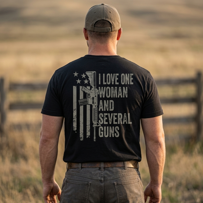 Person wearing I Love One Woman and Several Guns Shirt with American flag design, outdoors in a field.