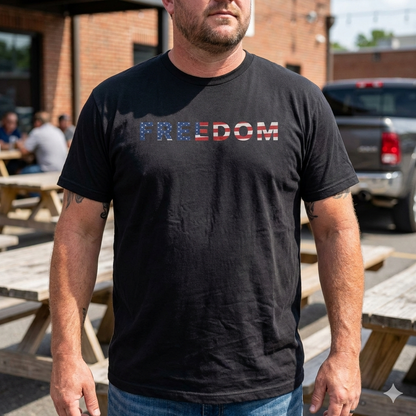 Man wearing Freedom 250 USA Anniversary Tee with 'Freedom' text, commemorating 250th birthday of America, outdoors.