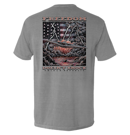 Freedom Doesn’t Knock Shirt with dramatic graphic, patriotic elements, stormy sky design, emphasizing liberty and strength.