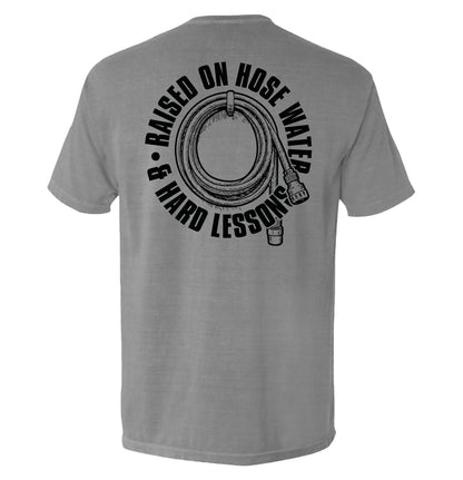 Gray tee with 'Raised On Hose Water & Hard Lessons Shirt' text, featuring blue collar nostalgia design on the back
