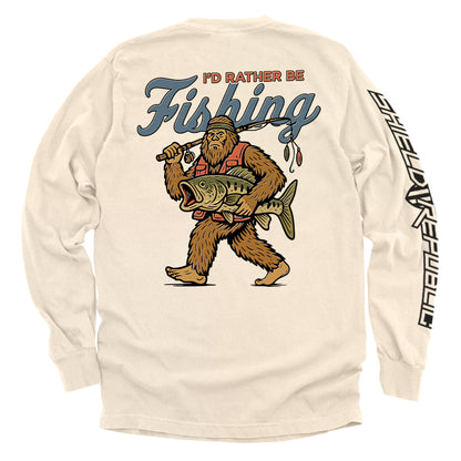 I’d Rather Be Fishing Bigfoot Shirt featuring Bigfoot with fishing gear and fresh catch, funny fishing graphic tee for anglers.