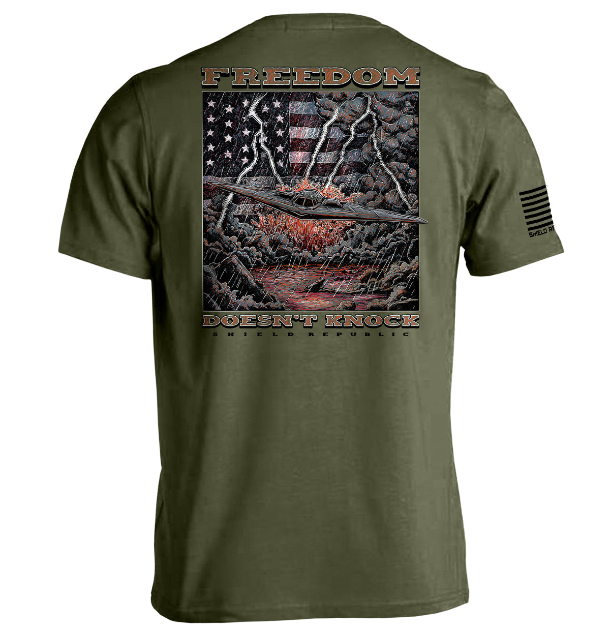 Freedom Doesn’t Knock Shirt with patriotic graphic, showing an American flag against a stormy backdrop on an olive tee.