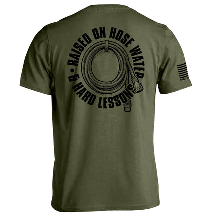 Green Raised On Hose Water & Hard Lessons Shirt - Blue Collar Nostalgia Tee with hose graphic on the back.