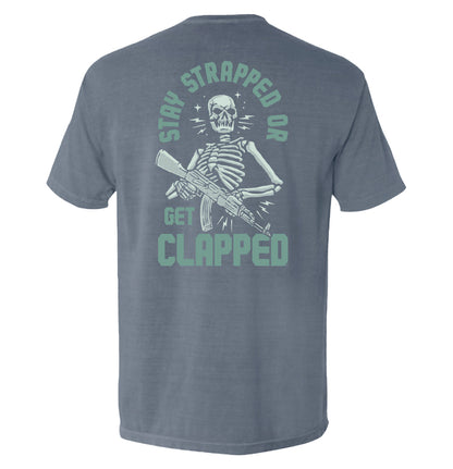 Stay Strapped or Get Clapped Shirt with tactical skeleton graphic and rifle illustration on back, bold typography, tactical graphic tee
