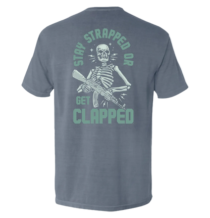 Stay Strapped or Get Clapped Shirt with skeleton holding rifle graphic, tactical tee, bold statement design
