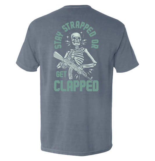 Stay Strapped or Get Clapped Shirt with skeleton holding rifle graphic, tactical tee, bold statement design