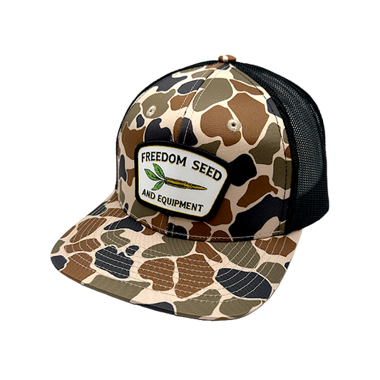 Camouflage-patterned cap with 'Freedom Seed' logo on a white background