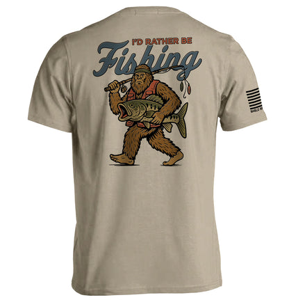 I’d Rather Be Fishing Bigfoot Shirt featuring Bigfoot with fishing rod and catch, perfect for fishing enthusiasts.