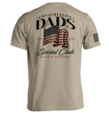 Conservative Dads Social Club T-Shirt featuring a patriotic design with an American flag and the words "Raising Patriots."