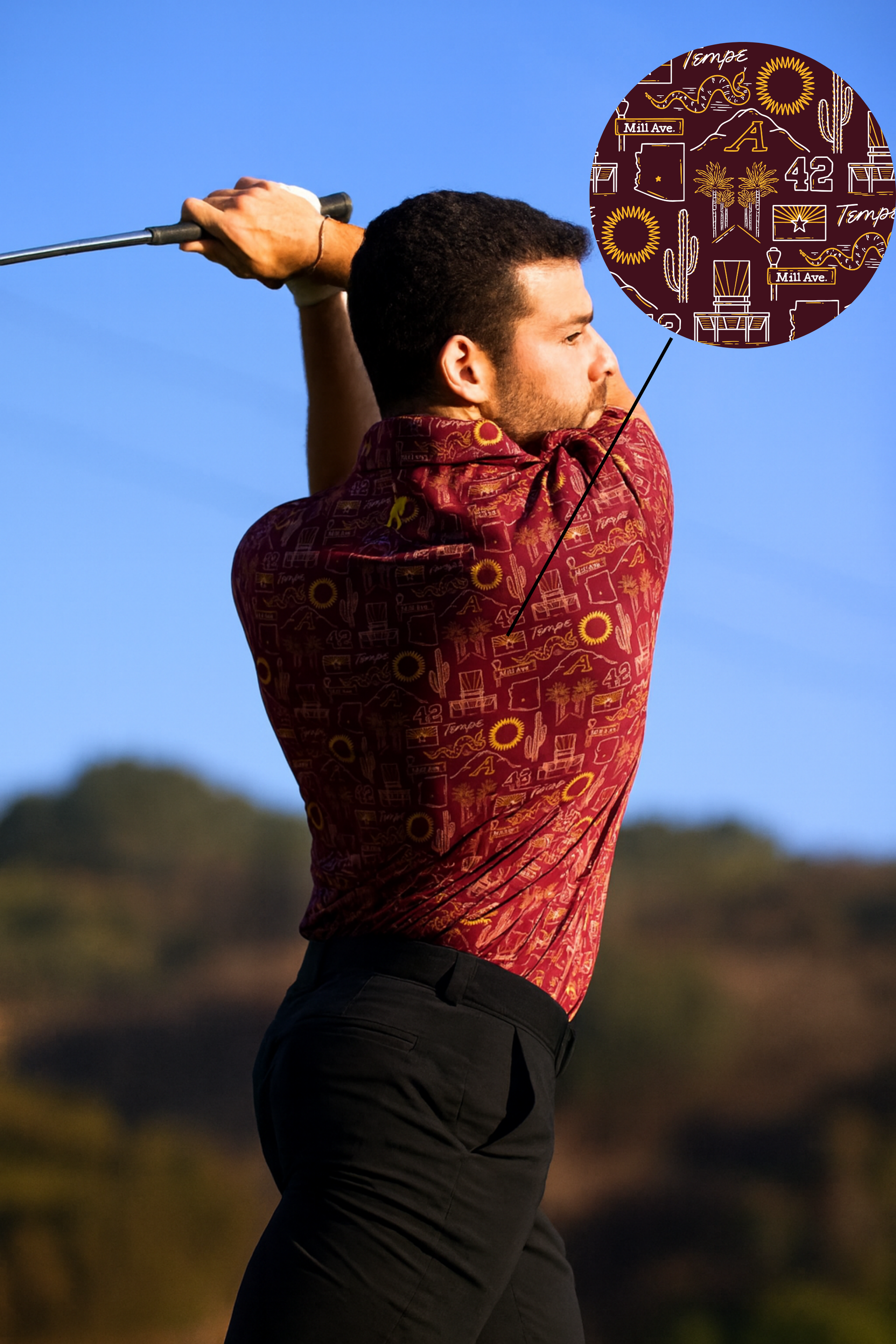 Man wearing Tempe football polo shirt "The Inferno" with bold design, swinging a golf club under clear blue sky.