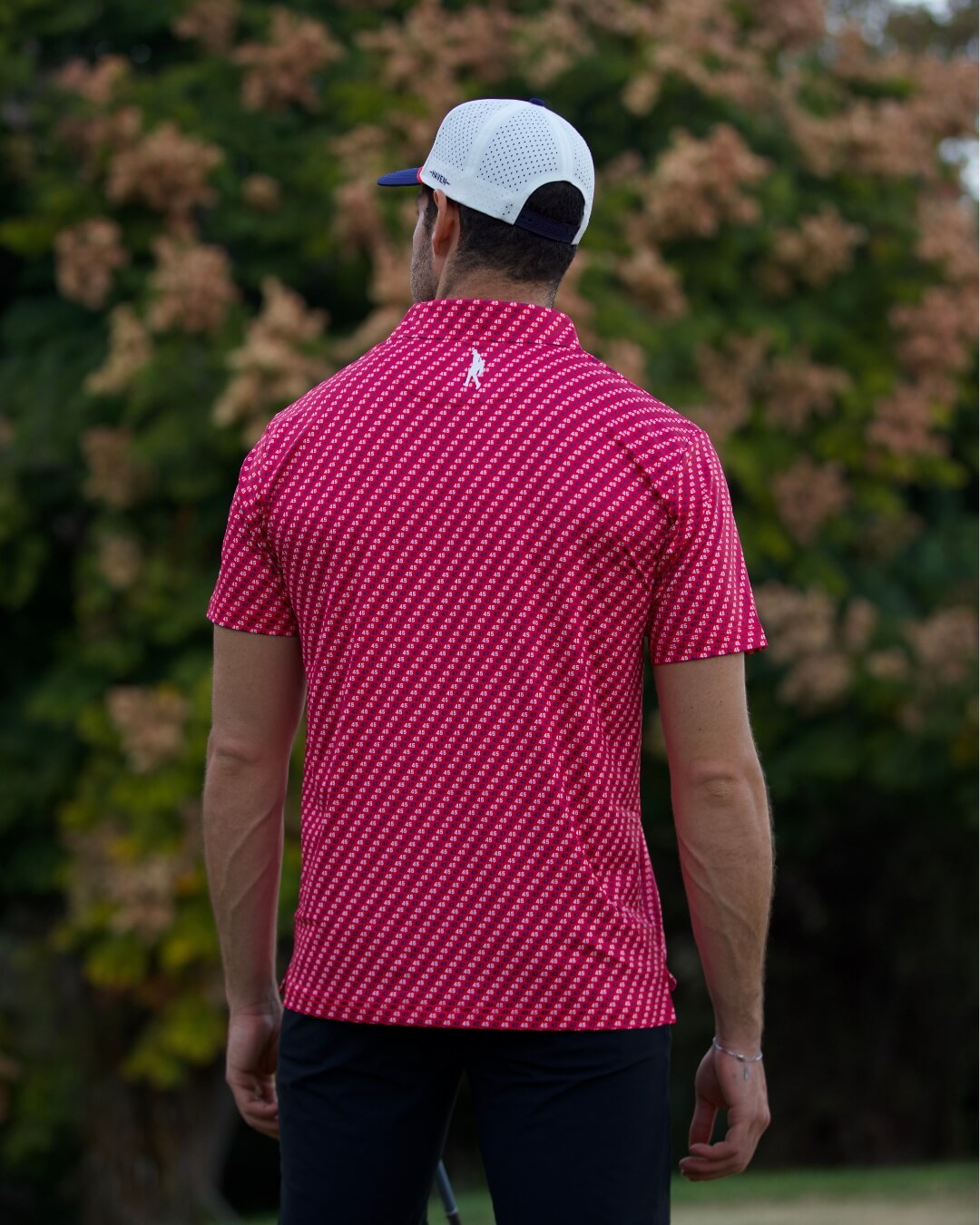 Back view of man wearing 45 polo shirt The Don by Haven Golf, red with white pattern, ideal for golfers seeking style and sun protection.