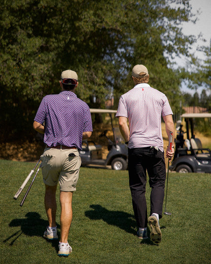 Golfers wearing 45 47 polo shirt by Haven Golf on a sunny course, displaying subtle patriotic style in red and navy print.
