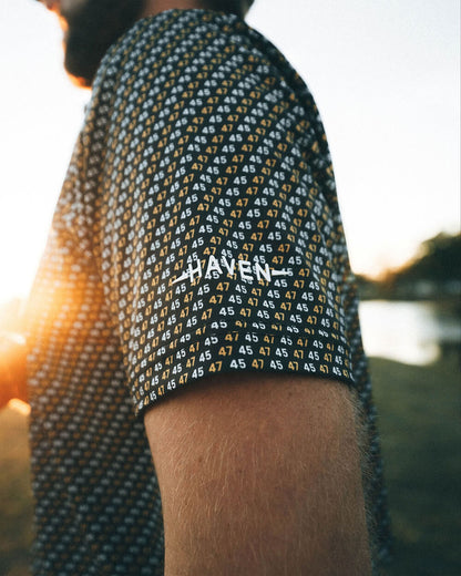 45 47 polo shirt with black and gold print by Haven Golf, featuring numbers 45 and 47 in a bold, patriotic design.
